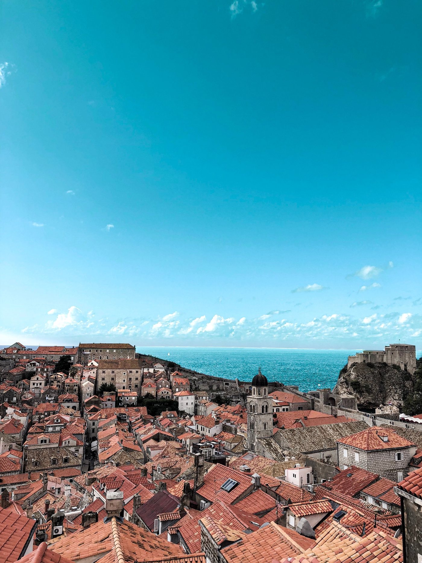 A Mediterranean coastline and old-town rooftops in Europe