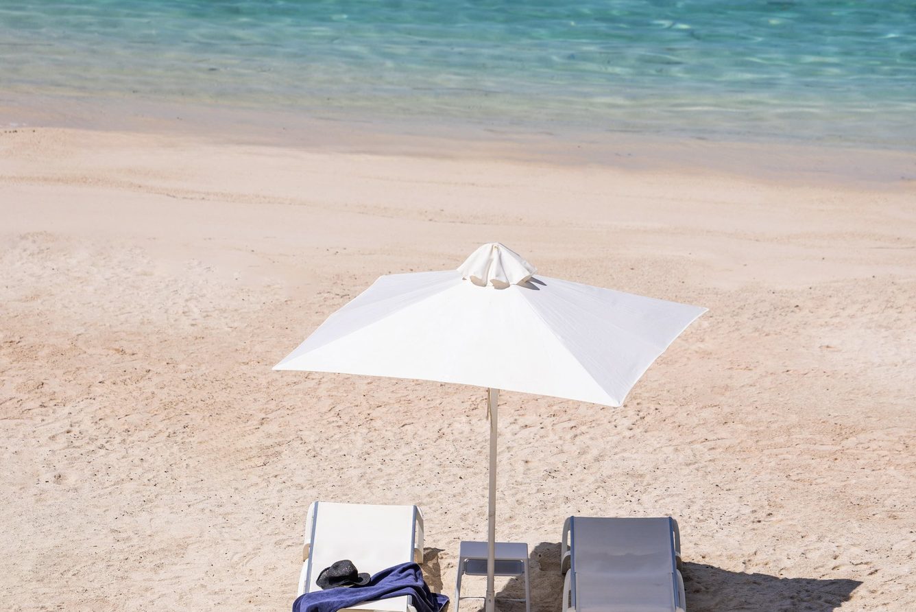 Sun loungers and a parasol on the private sandy beach at Kep Merli