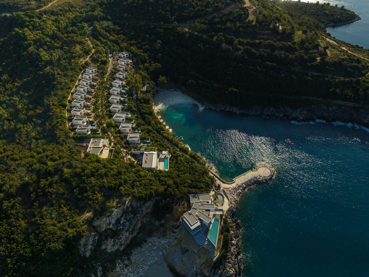 Aerial view of the Kep Merli peninsula, its villas terraced above a turquoise cove near Ksamil