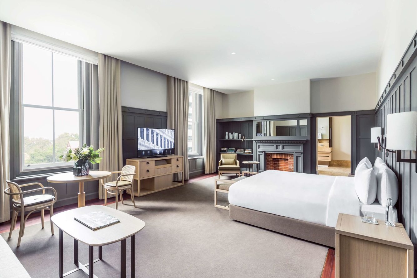 A suite at COMO The Treasury with a fireplace, sitting area and tall windows