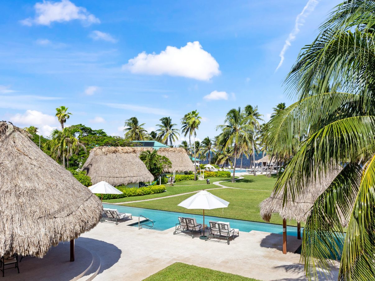 Pool, thatched palapa and lawns running down to the beach at Victoria House Resort & Spa