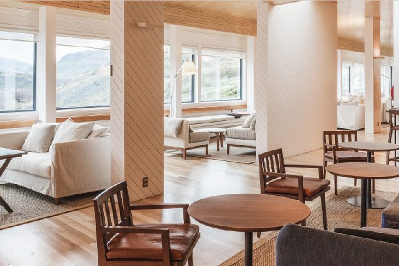 The lounge at Explora Torres del Paine, with sofas and picture windows over the park
