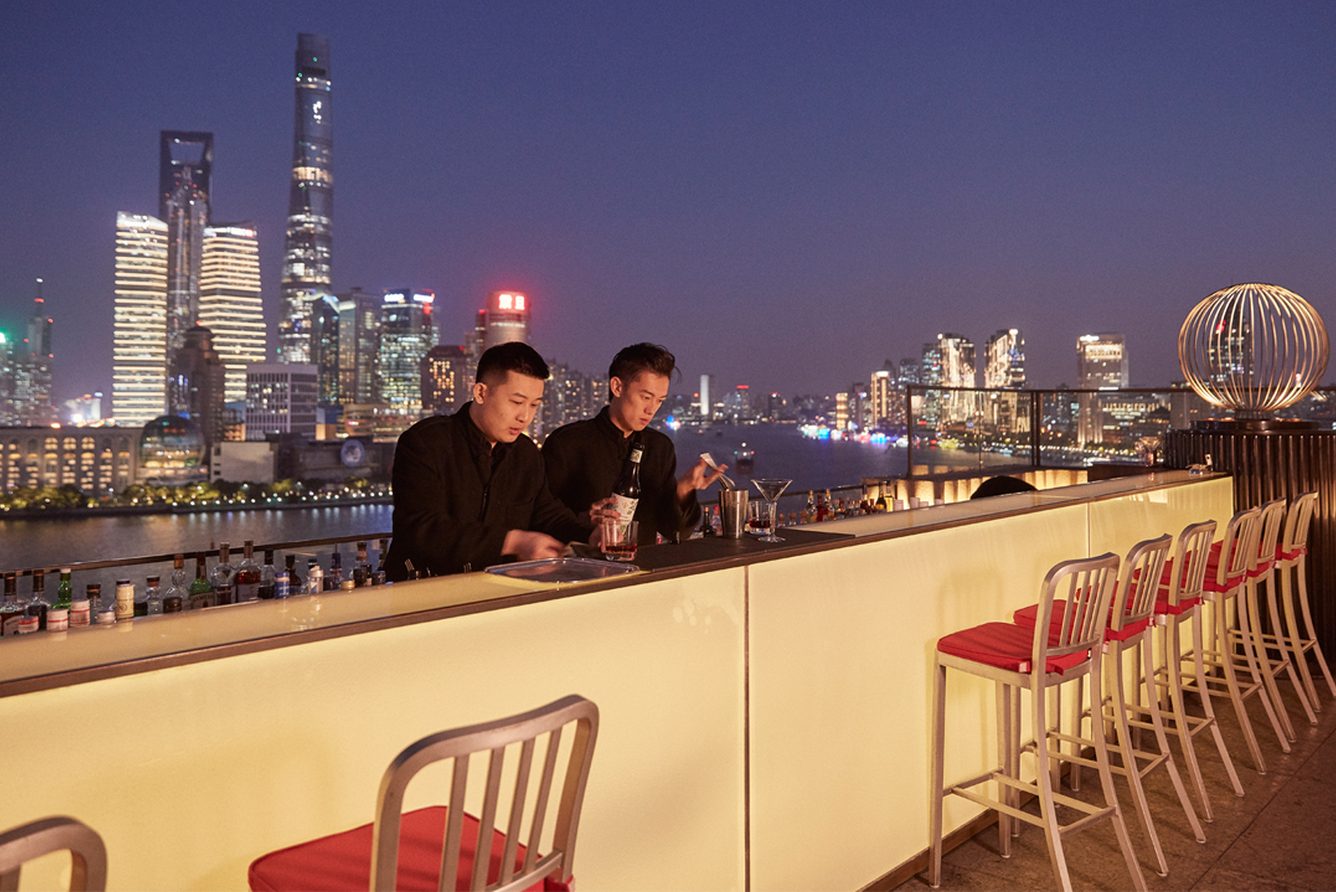 The rooftop terrace of The Peninsula Shanghai looking across the Huangpu River to the Pudong skyline