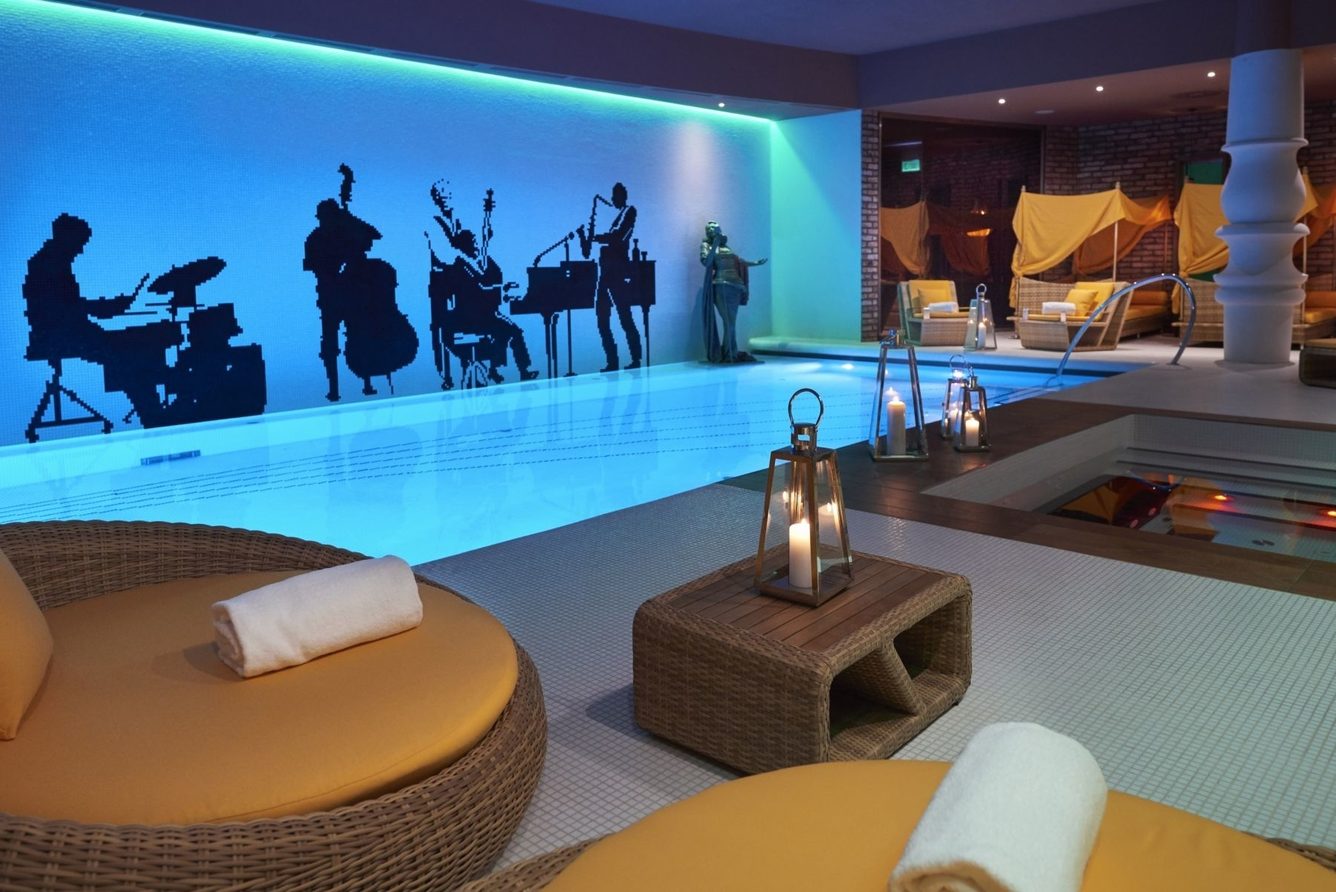 The Harmony Spa pool at Aria Hotel Budapest, its blue wall decorated with jazz-musician silhouettes