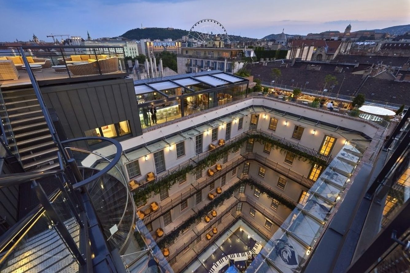 The rooftop terraces of Aria Hotel Budapest at dusk, with St Stephen's Basilica and the Budapest Eye beyond