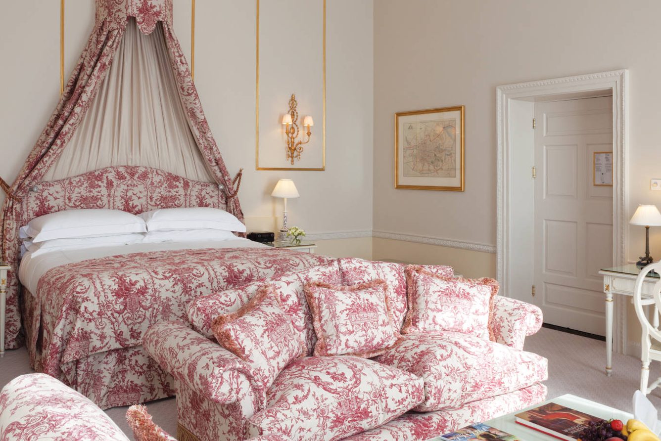 A canopy-bed suite interior at The Merrion Hotel with floral fabrics
