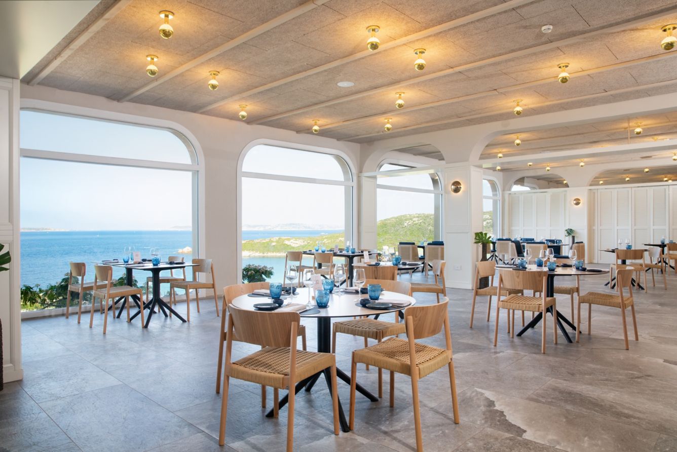 The resort's sea-view restaurant with arched windows over the bay