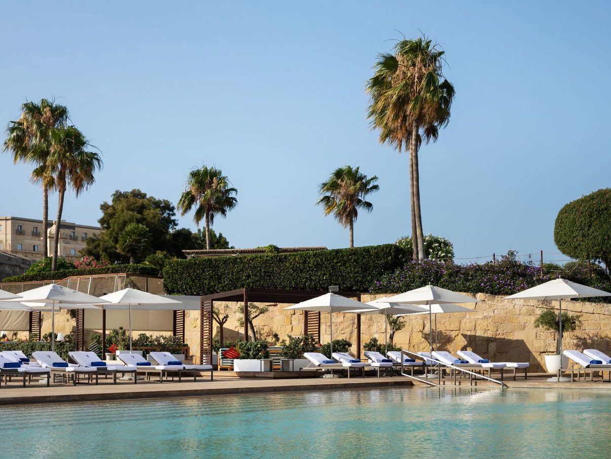 The Bastion Pool at The Phoenicia Malta, lined with loungers and palm trees