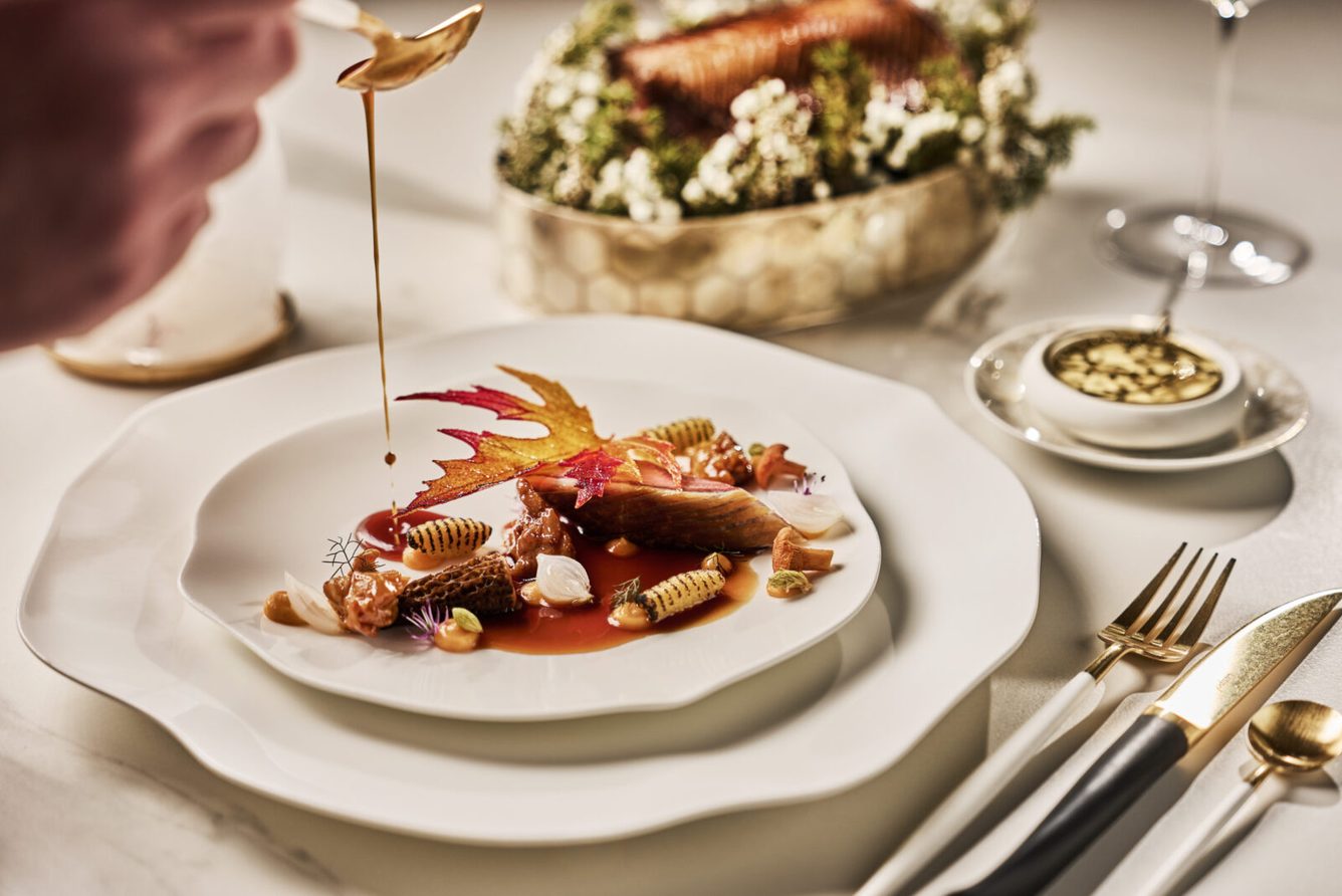 A plated dish being finished with sauce at Speilsalen, Britannia Hotel's restaurant