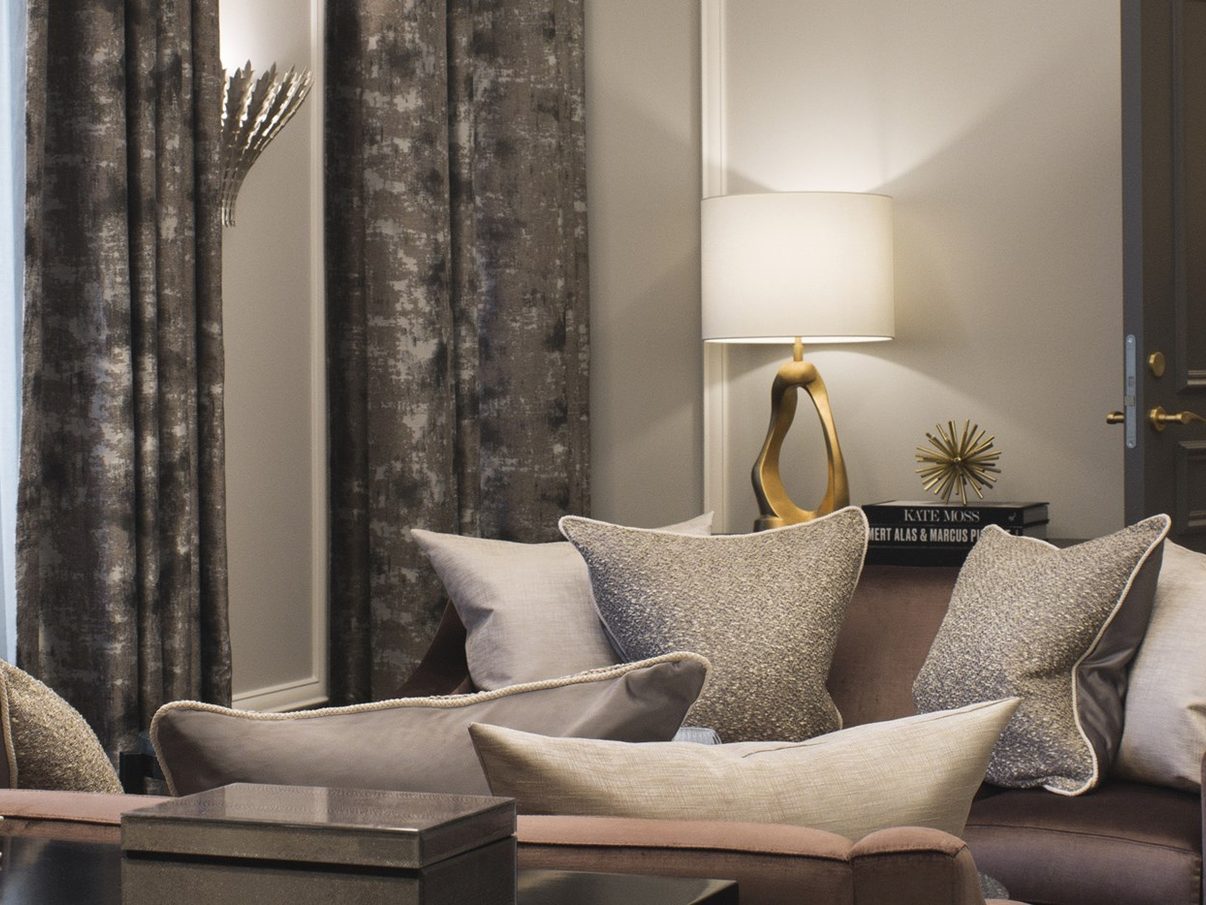 A suite sitting room at Britannia Hotel in Trondheim, with sofas, lamps and tall windows