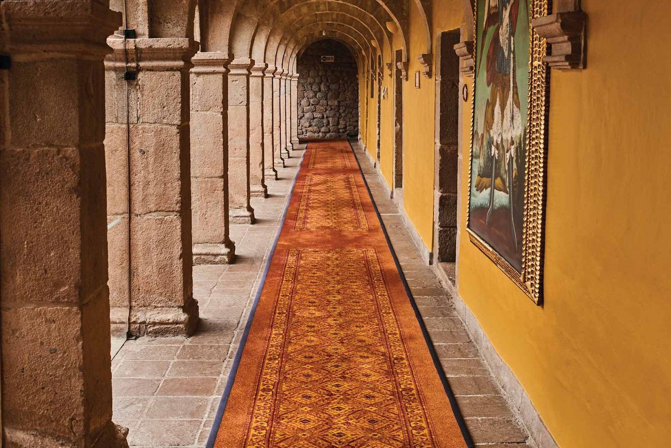 A vaulted stone cloister corridor at Monasterio