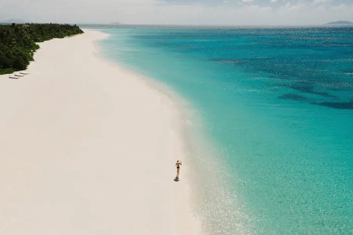 A white sandbar and shallow turquoise water on the shore of Pamalican Island at Amanpulo