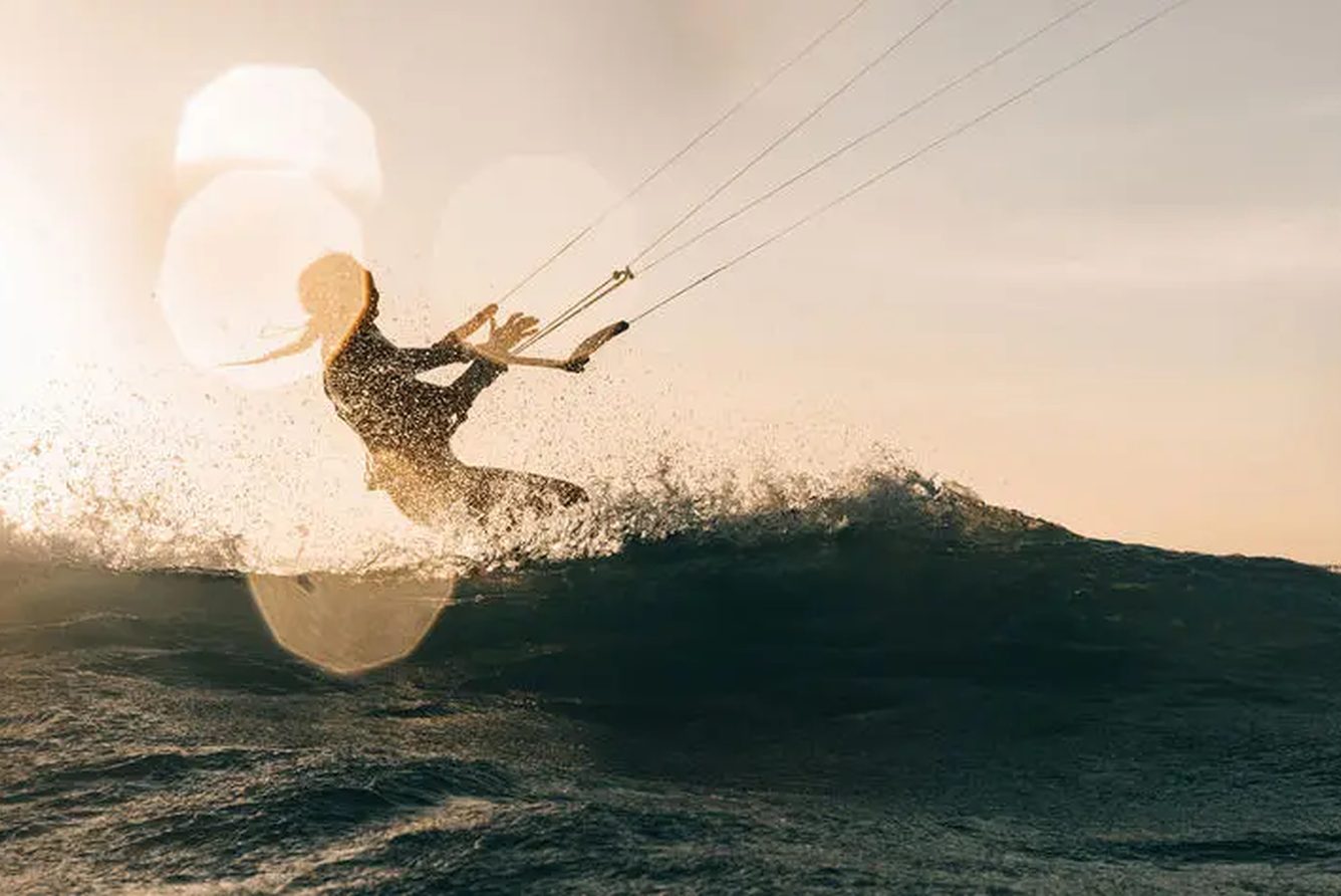 A kitesurfer skimming the water off Pamalican Island at Amanpulo