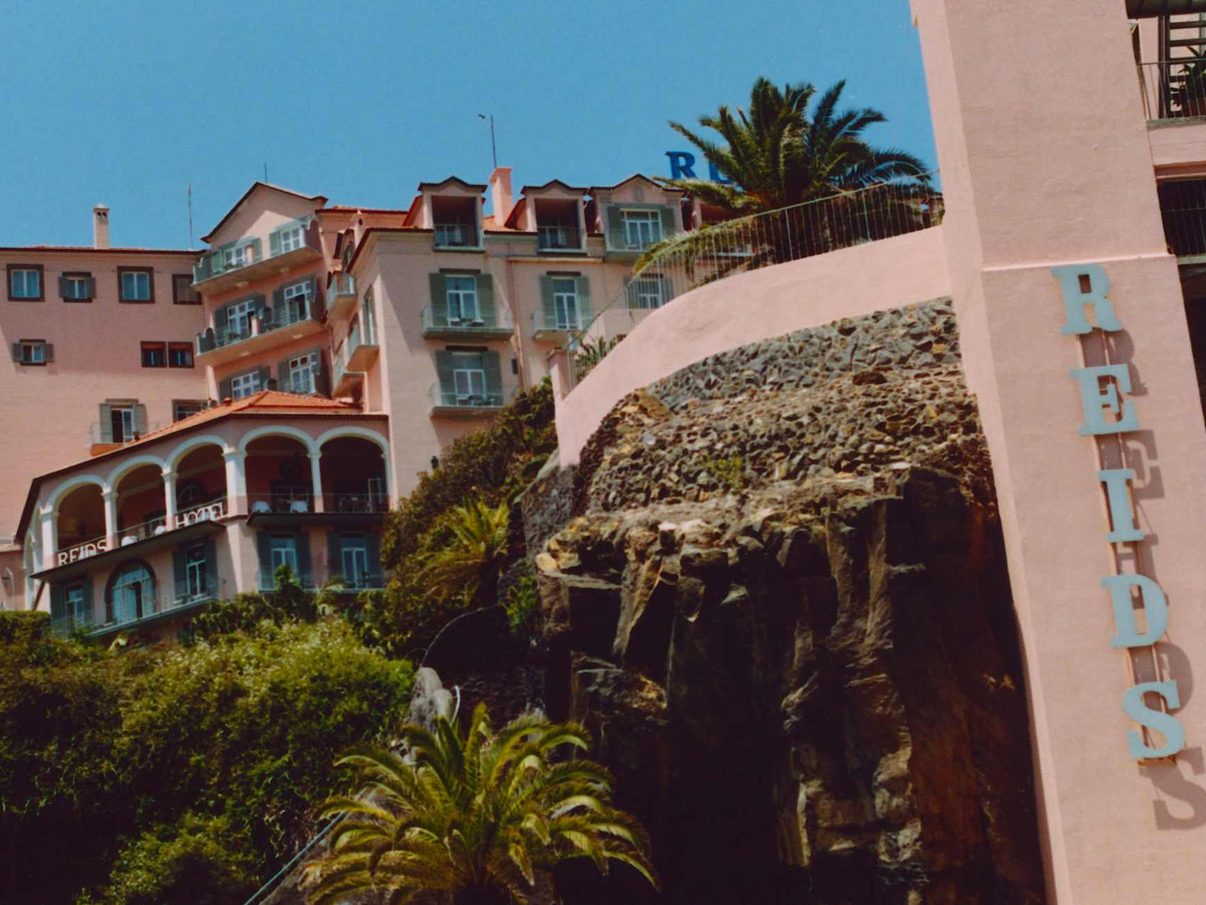 The pink palace of Reid's Palace rising above its clifftop gardens in Funchal, Madeira
