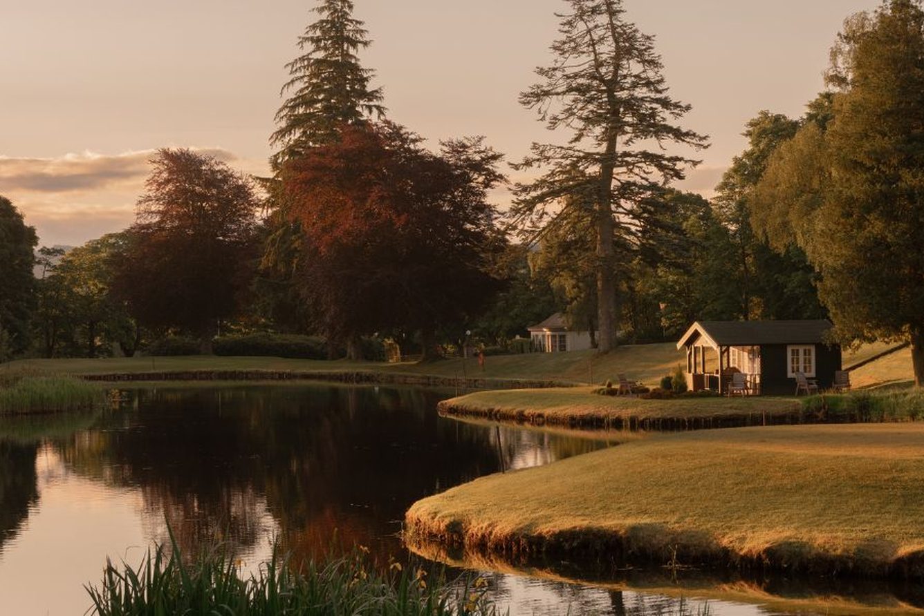A fishing hut beside a loch in the grounds of the Gleneagles estate at sunset, Perthshire