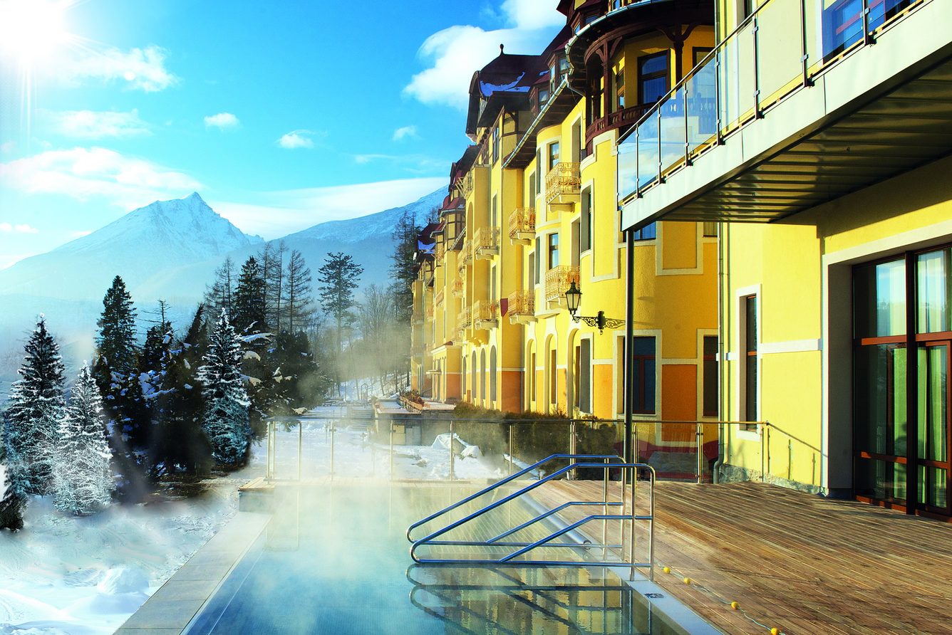 The outdoor pool steaming in winter beside the hotel, Tatra peaks beyond
