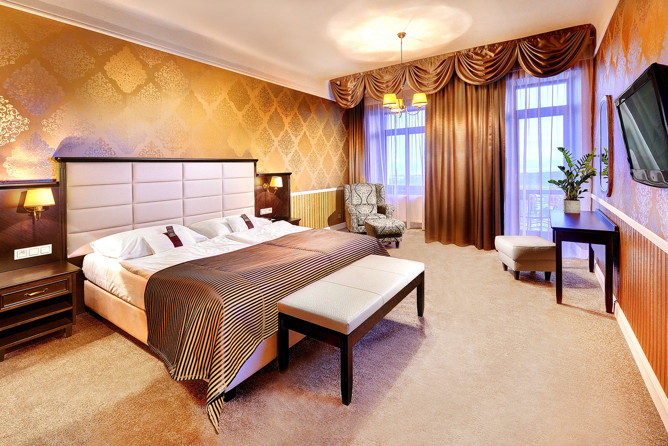 A classic double room with patterned wallpaper and a mountain-view window at Grandhotel Praha
