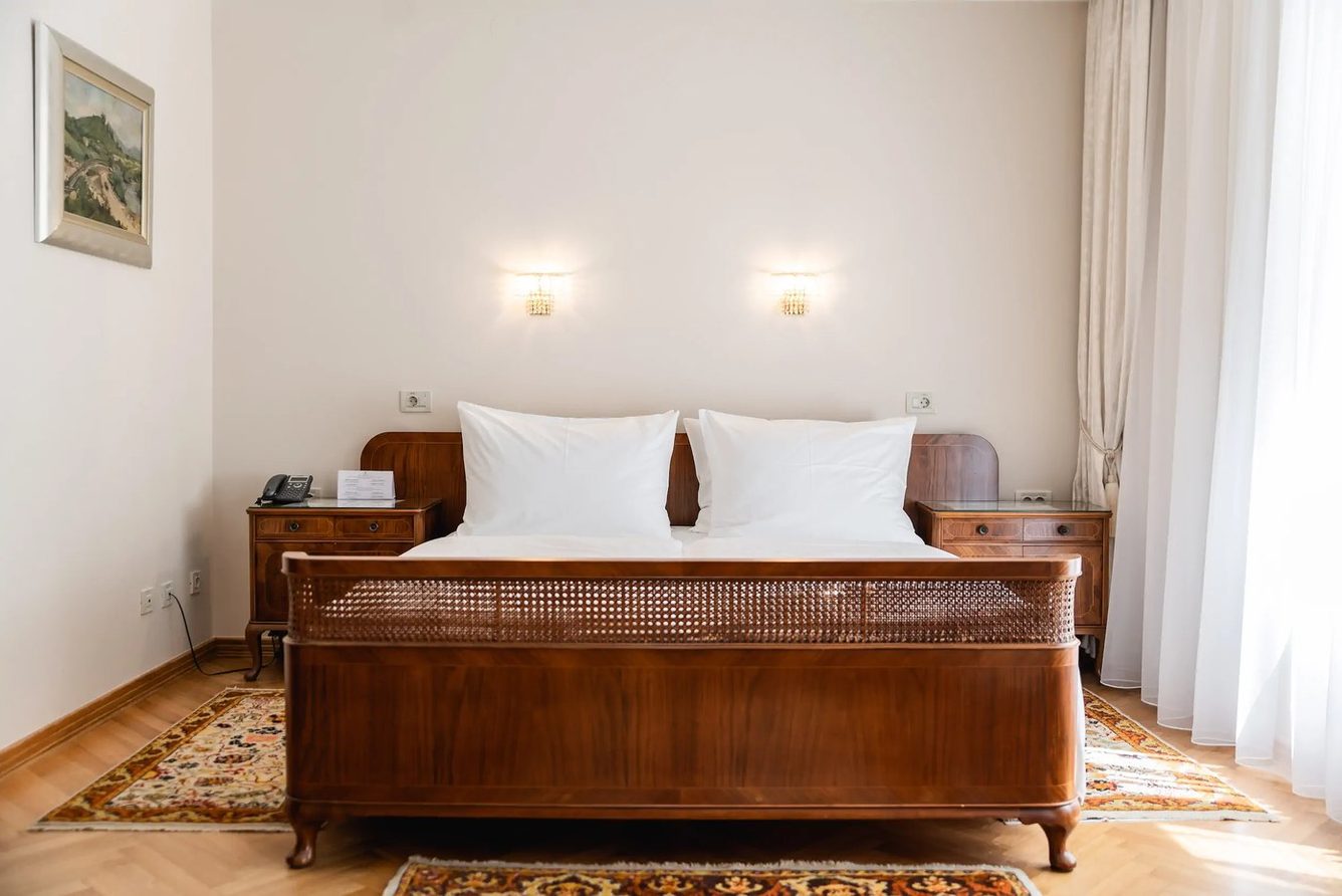 A bedroom at Vila Bled with a carved wooden bed and period furniture