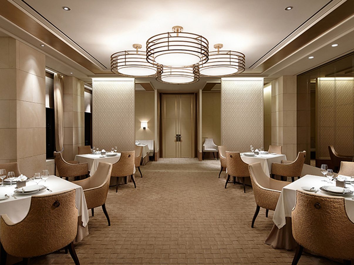A private dining room at The Shilla Seoul with ring chandeliers and tables set for service
