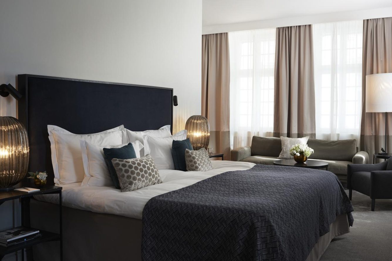 A junior suite at Grand Hotel Stockholm with a king bed and seating area