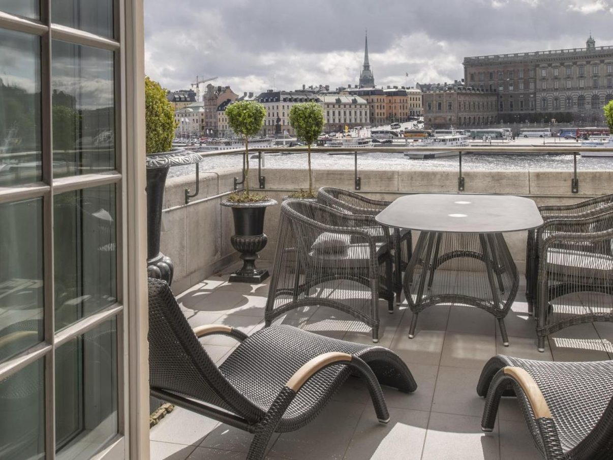 A terrace suite at Grand Hotel Stockholm with a sofa, dining table and tall windows