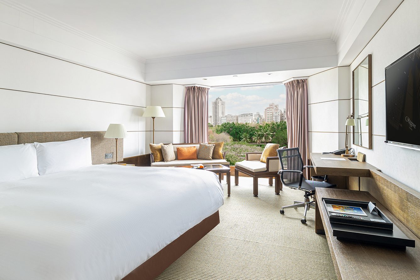 Guest room at Regent Taipei with twin beds, a work desk and city views