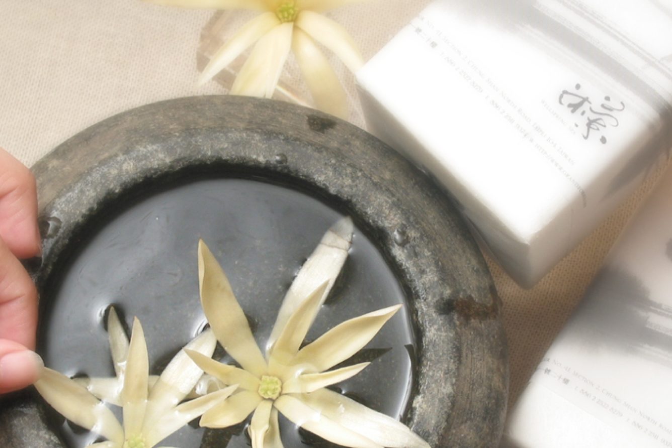 Spa detail with frangipani flowers and folded towels at the Wellspring Spa