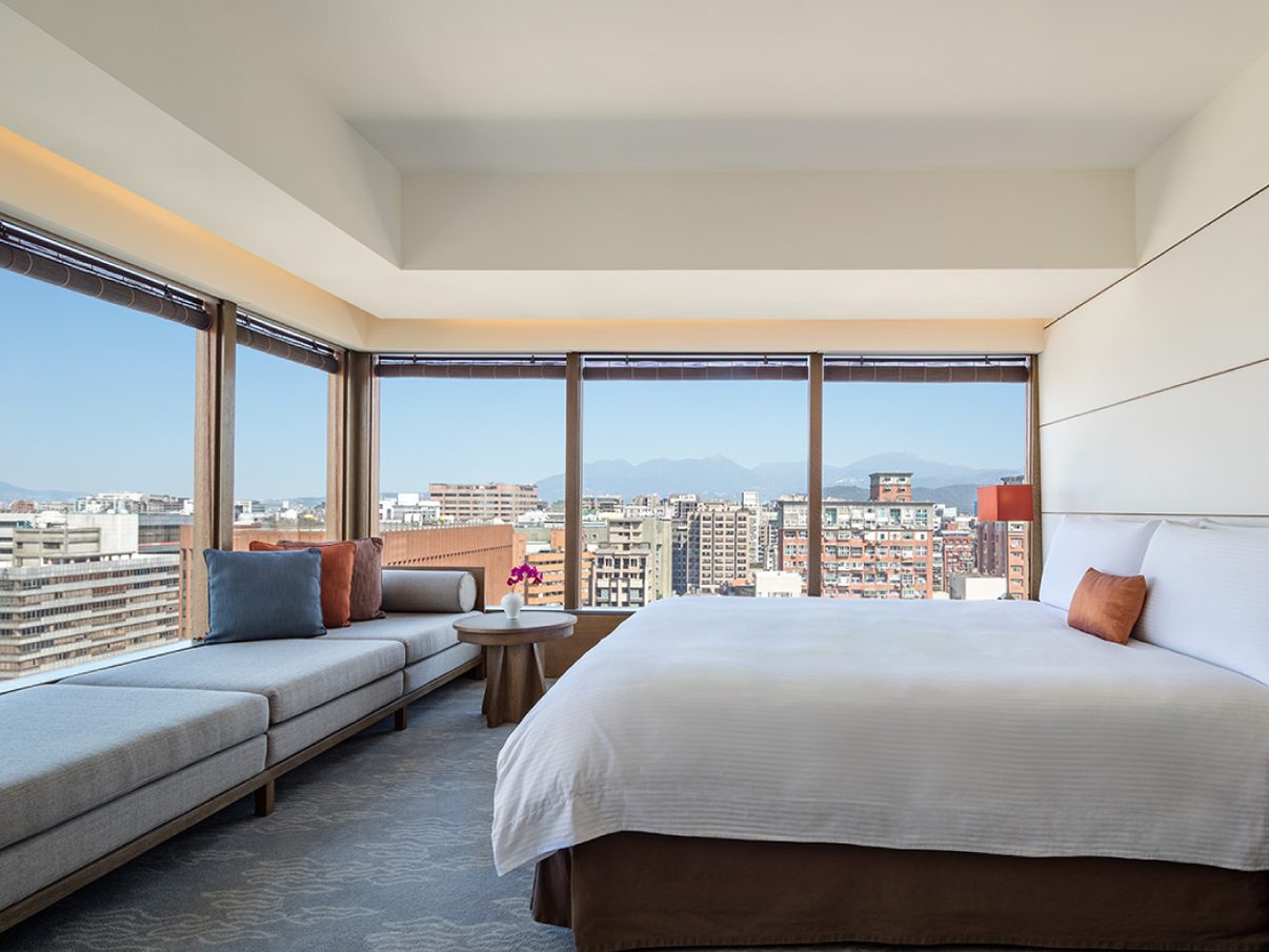 Regent Taipei guest room with a window seat and skyline views over Zhongshan