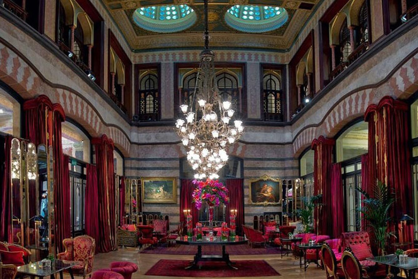 The Kubbeli Salon at Pera Palace, a grand domed lounge with red drapes, chandeliers and velvet chairs