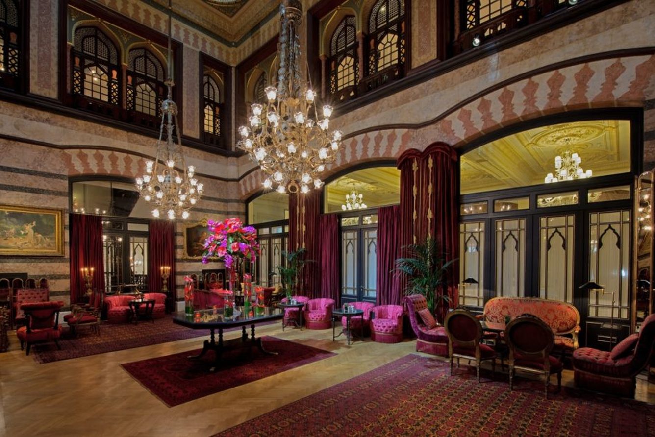 Another view of the Kubbeli Salon lounge at Pera Palace, with crystal chandeliers and velvet armchairs