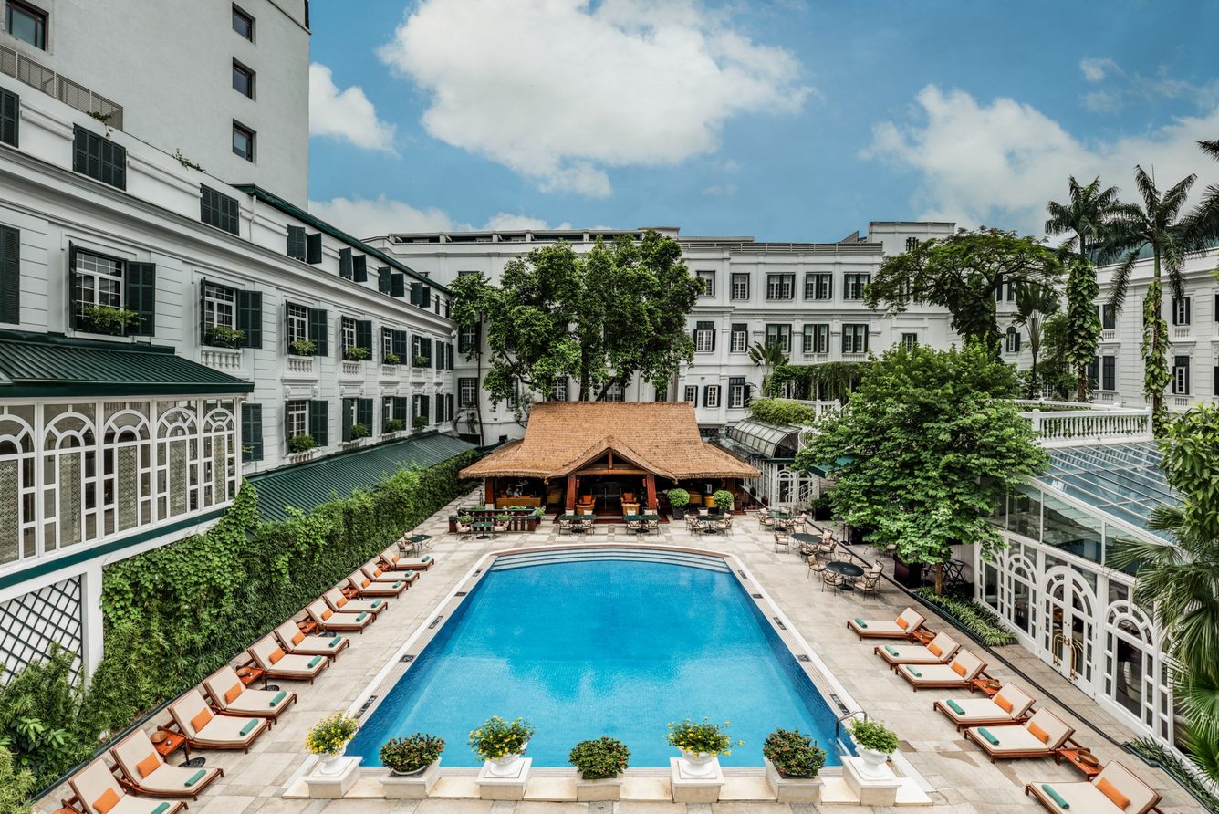 The outdoor pool of Sofitel Legend Metropole Hanoi overlooked by the hotel's historic wing